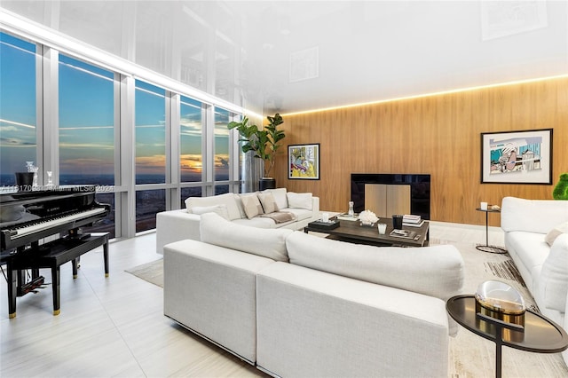 living room featuring wood walls and light tile patterned floors