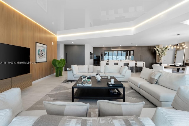 living room featuring wood walls and a notable chandelier