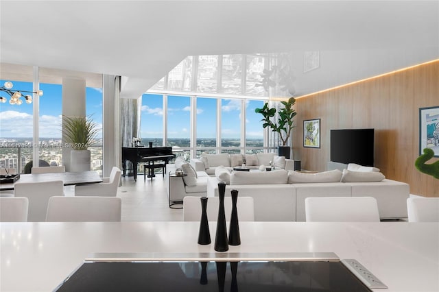 tiled living room featuring a wall of windows and wooden walls