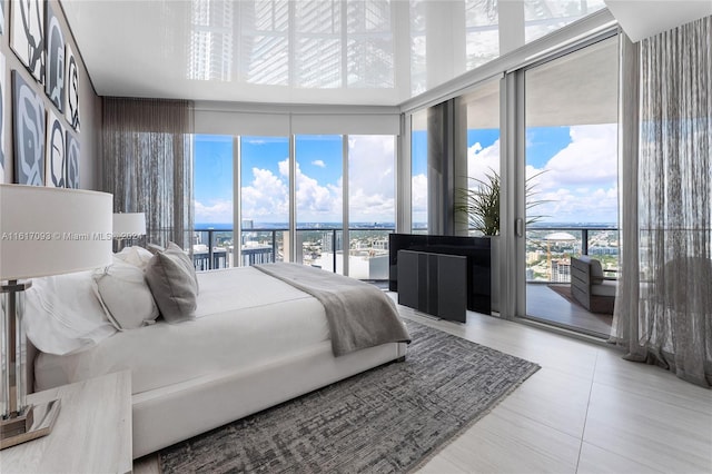 bedroom featuring a water view, light tile patterned floors, and access to exterior