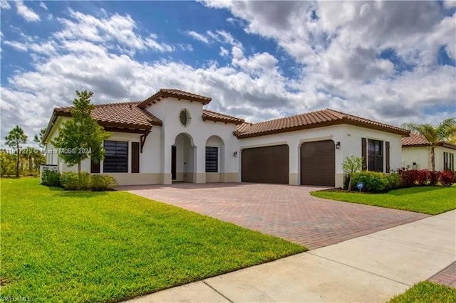 mediterranean / spanish home featuring a garage and a front lawn