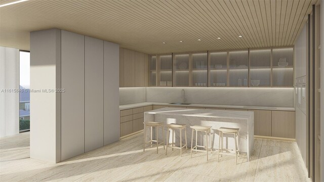 kitchen featuring wood ceiling, a kitchen bar, and sink