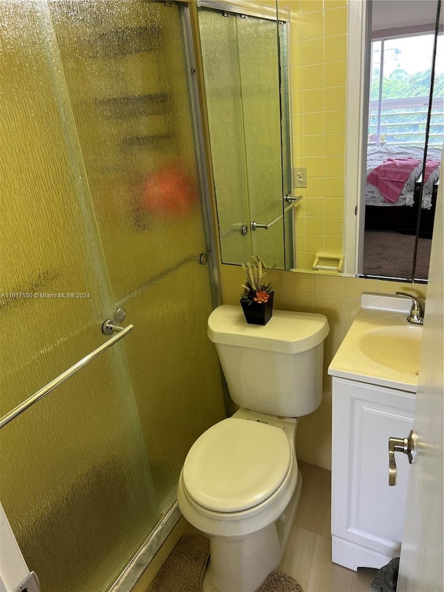 bathroom with tile walls, toilet, and vanity