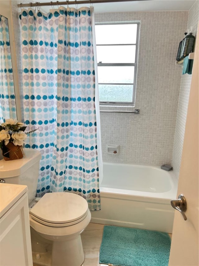 full bathroom with toilet, vanity, and shower / tub combo with curtain