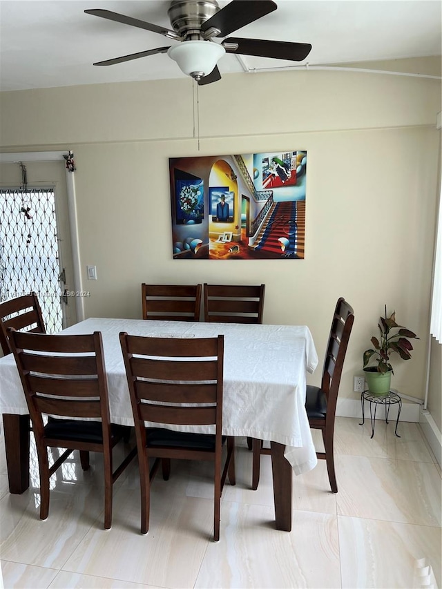 tiled dining room featuring ceiling fan