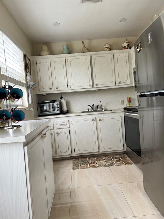 kitchen with sink, appliances with stainless steel finishes, and light tile patterned floors