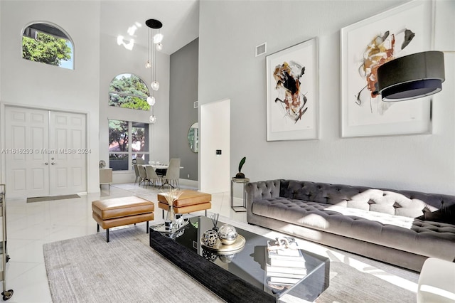 tiled living area with plenty of natural light, a high ceiling, and visible vents