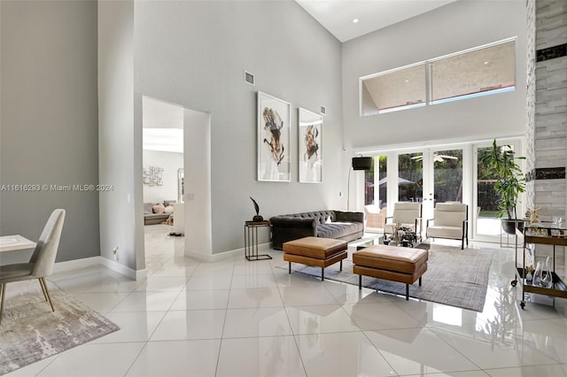 tiled living room featuring french doors and a high ceiling