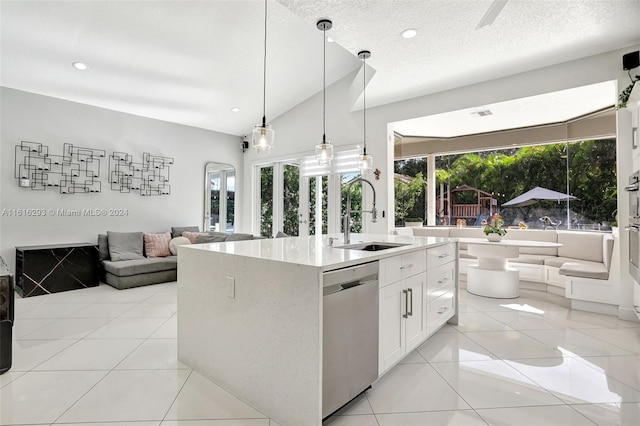 kitchen featuring light tile patterned floors, hanging light fixtures, dishwasher, sink, and white cabinetry