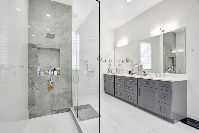 bathroom with double sink vanity, a shower with door, and tile patterned floors