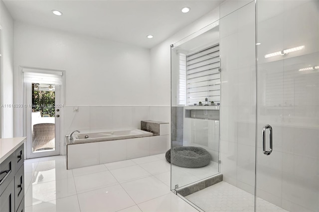 bathroom with tile patterned floors, vanity, and shower with separate bathtub