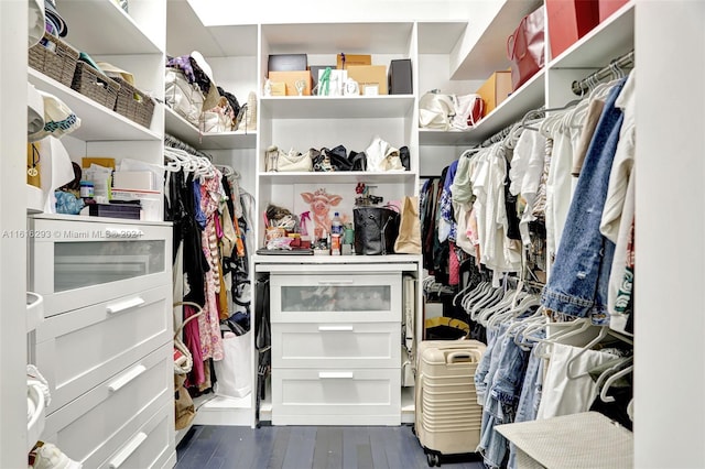 walk in closet with dark wood-type flooring