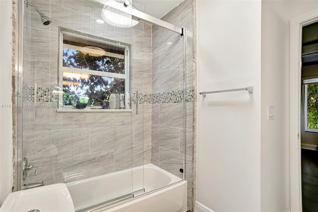 bathroom featuring bath / shower combo with glass door