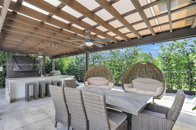 view of patio / terrace featuring ceiling fan, a bar, a pergola, and an outdoor kitchen