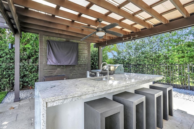 view of patio with exterior kitchen, ceiling fan, a pergola, and a bar