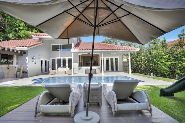 view of swimming pool featuring french doors and a lawn