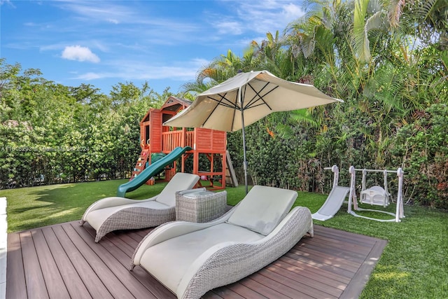 deck with a playground and a lawn