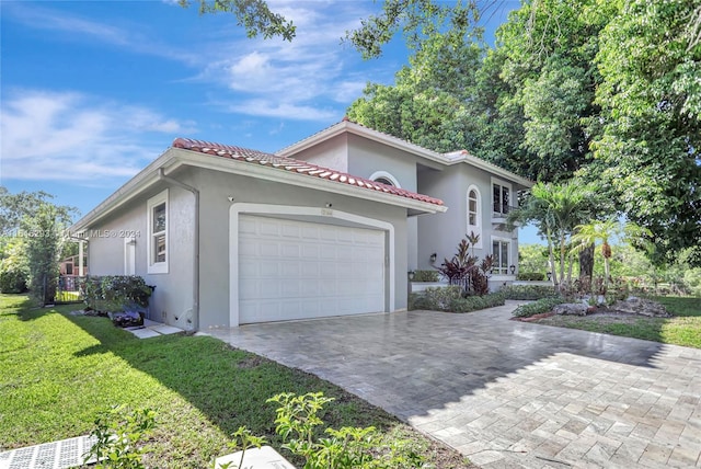 mediterranean / spanish-style house with a garage and a front lawn