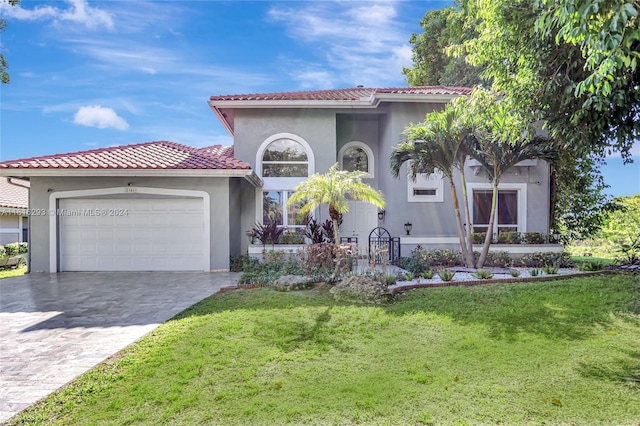 mediterranean / spanish house featuring a front yard and a garage