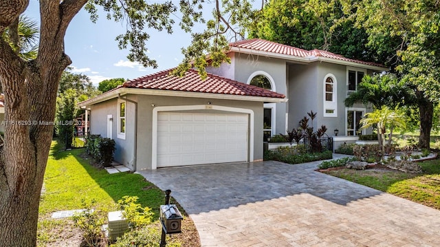 mediterranean / spanish home with a front yard and a garage