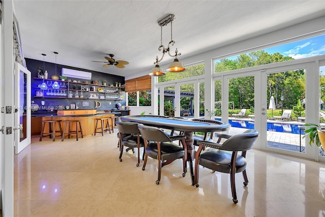 dining room featuring bar area, ceiling fan, french doors, and an AC wall unit