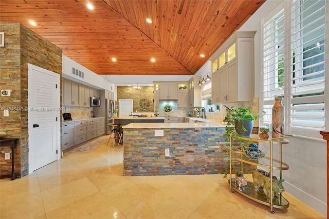 kitchen with gray cabinetry, wooden ceiling, backsplash, high vaulted ceiling, and kitchen peninsula