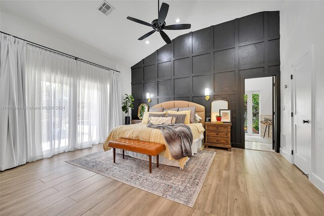 bedroom with ceiling fan, light hardwood / wood-style floors, and high vaulted ceiling