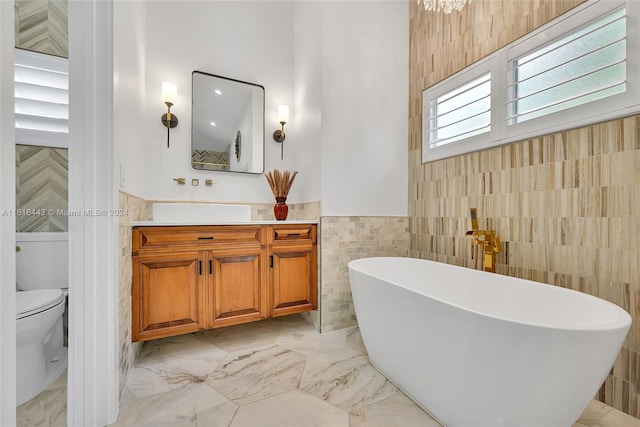 bathroom with a bathtub, toilet, tile walls, and vanity