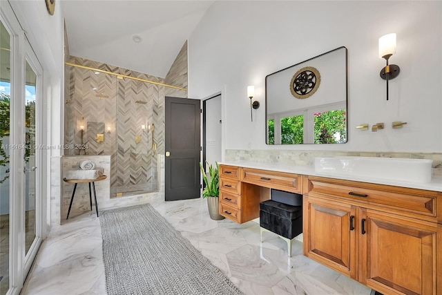 bathroom featuring a tile shower, a wealth of natural light, vanity, and vaulted ceiling