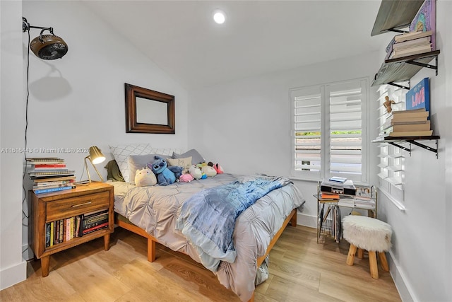 bedroom with light wood-type flooring and vaulted ceiling