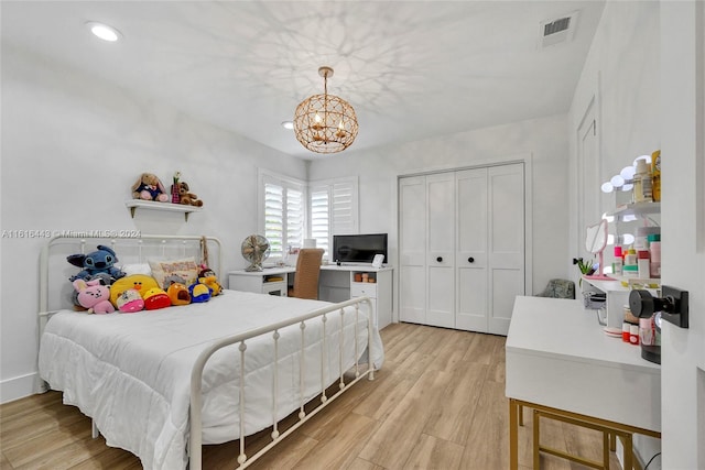 bedroom with an inviting chandelier, a closet, and light hardwood / wood-style flooring