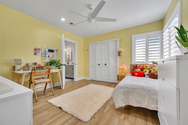 bedroom with connected bathroom, a closet, light hardwood / wood-style flooring, and ceiling fan