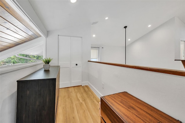 hallway featuring light hardwood / wood-style floors and vaulted ceiling