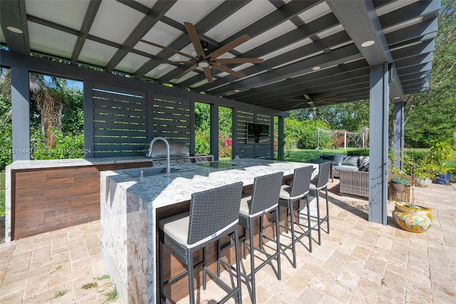 view of patio / terrace featuring ceiling fan, area for grilling, and an outdoor wet bar