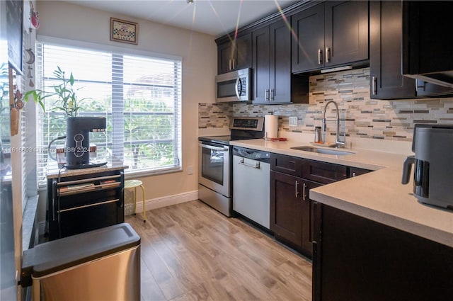 kitchen with appliances with stainless steel finishes, tasteful backsplash, a healthy amount of sunlight, and sink