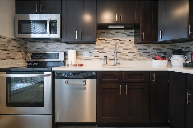 kitchen featuring backsplash, dark brown cabinetry, sink, and appliances with stainless steel finishes