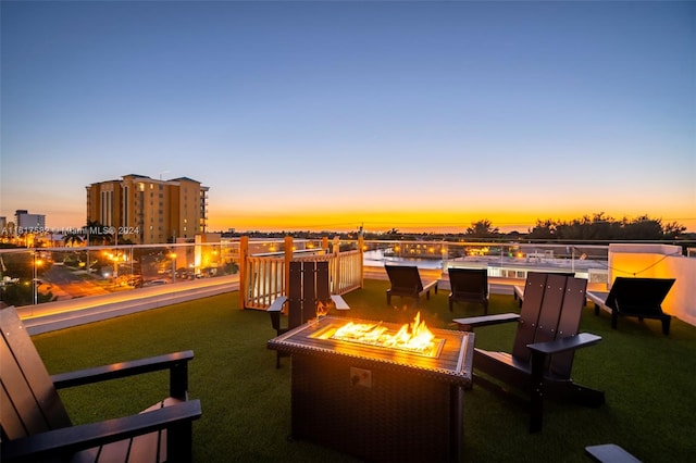 patio terrace at dusk with a yard and a fire pit