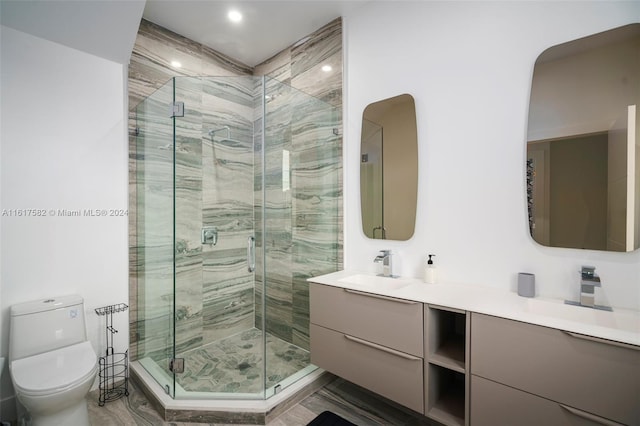 bathroom featuring dual vanity, an enclosed shower, and toilet