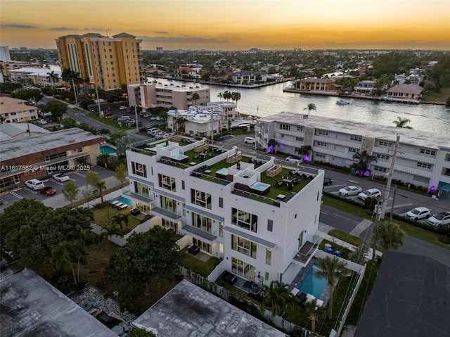 aerial view at dusk featuring a water view