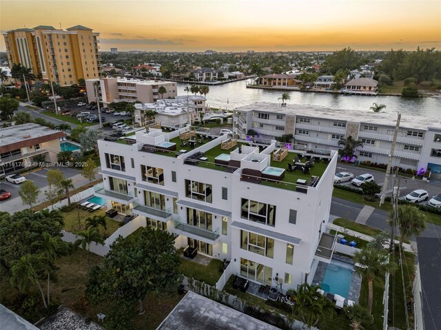 aerial view at dusk featuring a water view