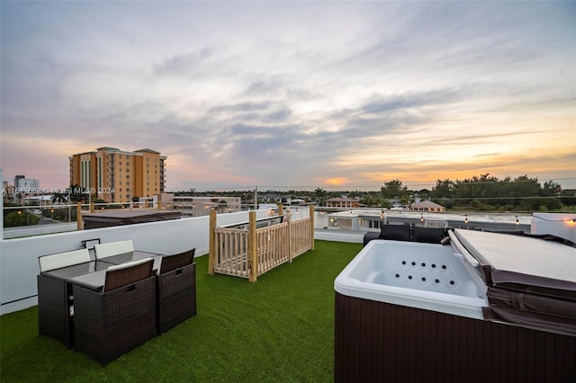 yard at dusk featuring a boat dock and a hot tub