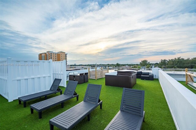 yard at dusk featuring a hot tub