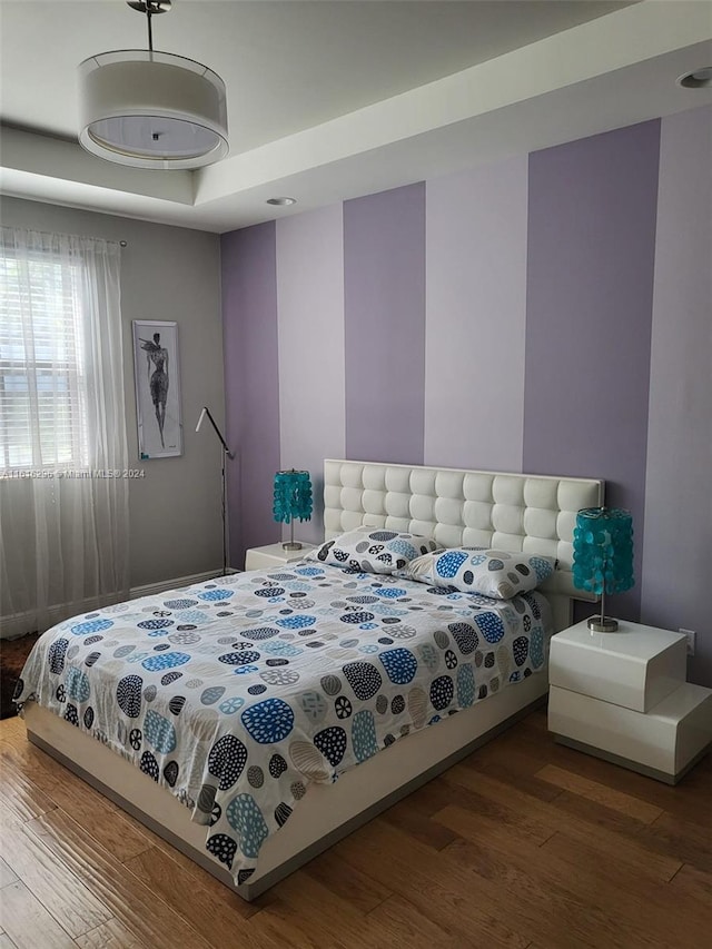 bedroom featuring a tray ceiling and wood finished floors
