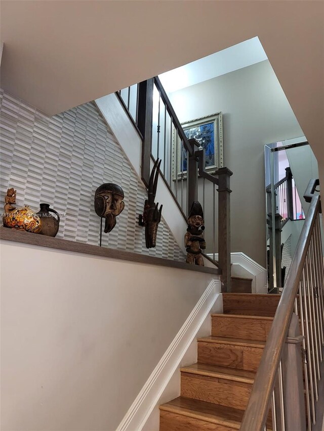 staircase with wood finished floors and baseboards