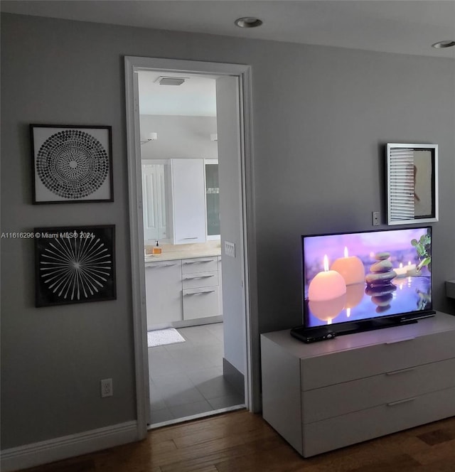 bedroom featuring baseboards, visible vents, wood finished floors, and ensuite bathroom