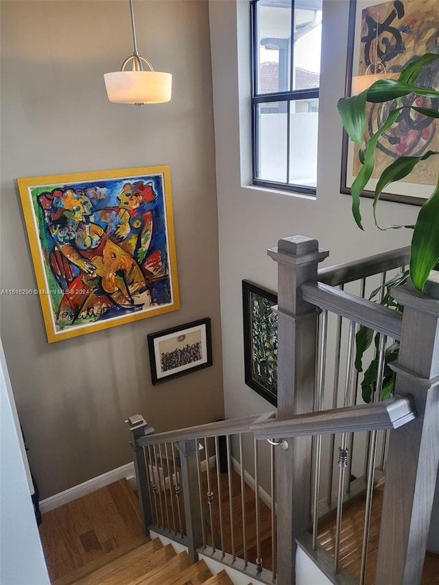 staircase featuring baseboards and wood finished floors