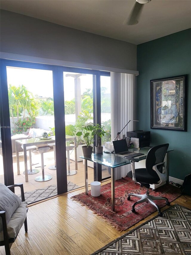 home office with hardwood / wood-style flooring and ceiling fan