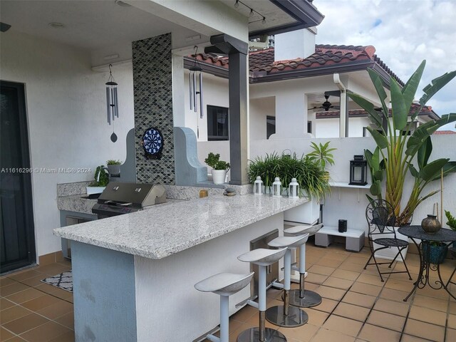 kitchen with a kitchen bar, kitchen peninsula, and tile patterned flooring