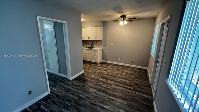 interior space with tasteful backsplash, white cabinets, and dark hardwood / wood-style floors