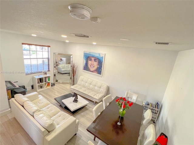 living room featuring a textured ceiling and light wood-type flooring